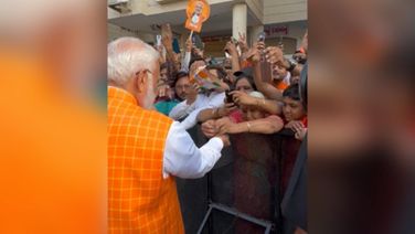 Woman ties rakhi to PM Modi as huge crowd gathers outside polling booth in Ahmedabad