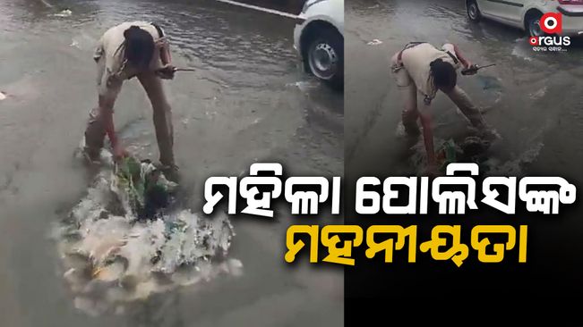 A woman police officer is cleaning the drain herself